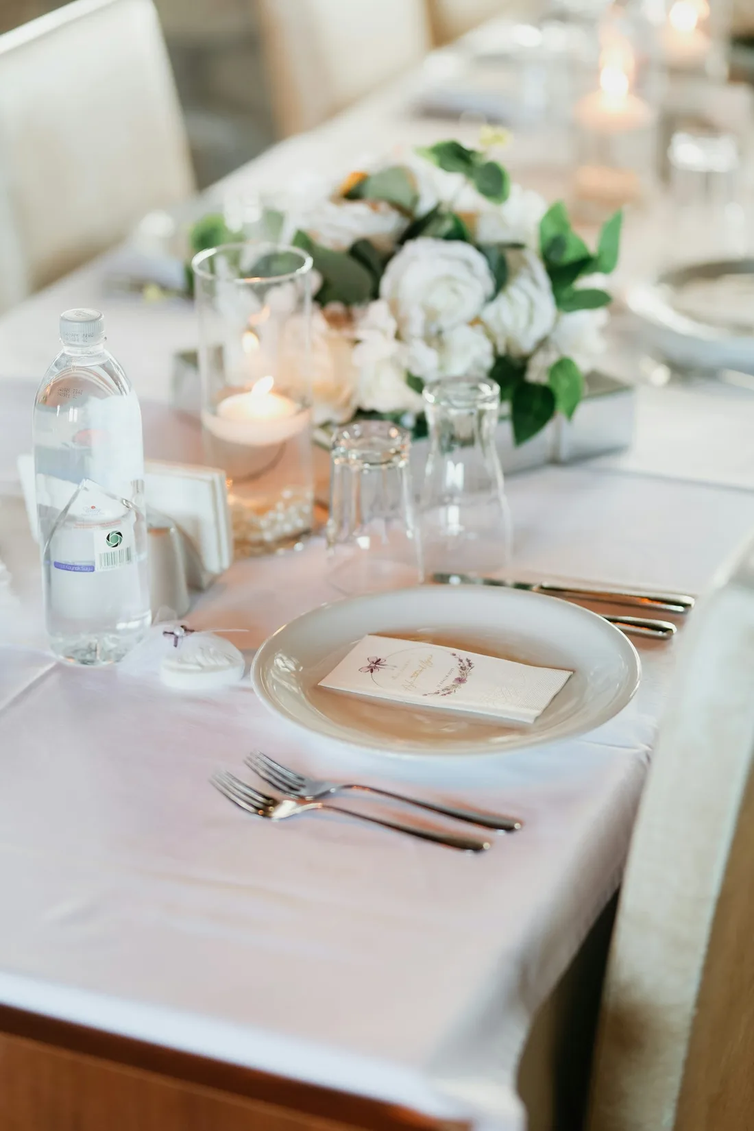 A table set with candles, flowers and glasses